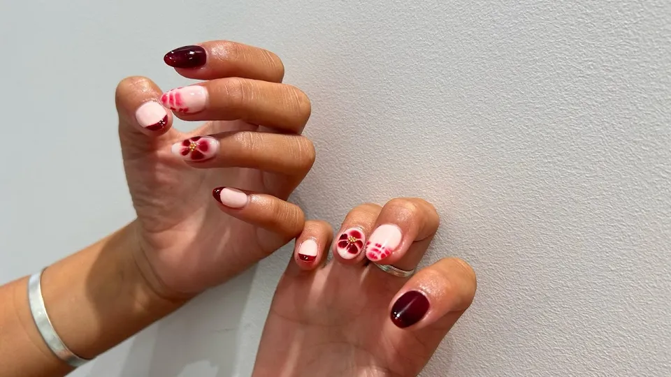 Intricate nail art design with detailed green botanical patterns